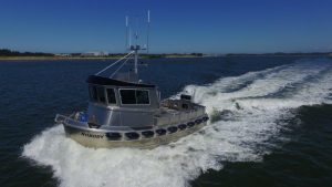 Front and side view of a North River Bristol Bay aluminum fishing boat on the water.