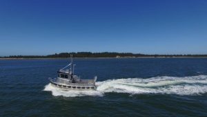 Side profile view of a North River Bristol Bay aluminum fishing boat on the water.